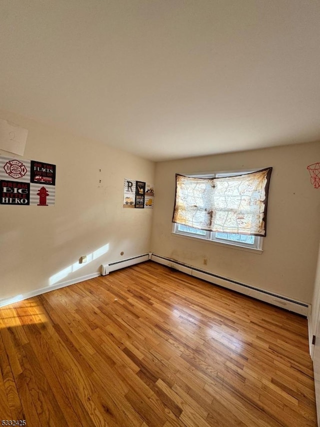 spare room with light hardwood / wood-style floors and a baseboard radiator