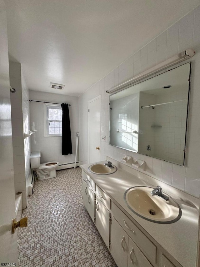 bathroom featuring vanity, baseboard heating, tile walls, tile patterned flooring, and toilet