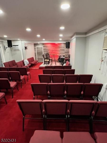 miscellaneous room with carpet floors and a wall mounted AC