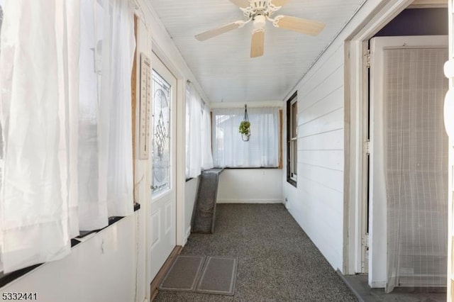 hallway with wooden walls and dark colored carpet