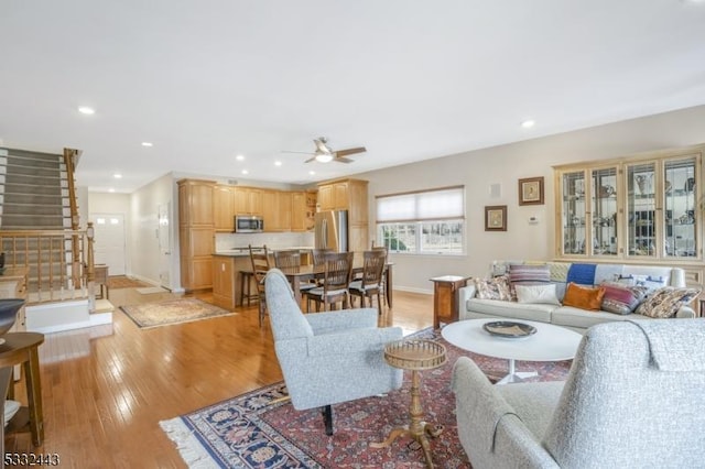 living room featuring light wood-type flooring and ceiling fan