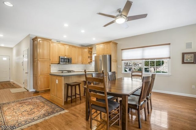 dining room with light hardwood / wood-style floors and ceiling fan