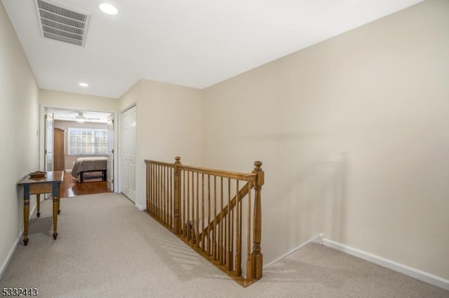 hallway featuring light colored carpet