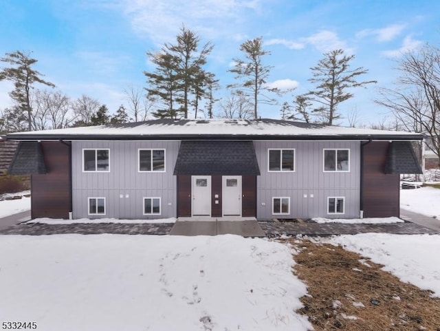 view of snow covered rear of property