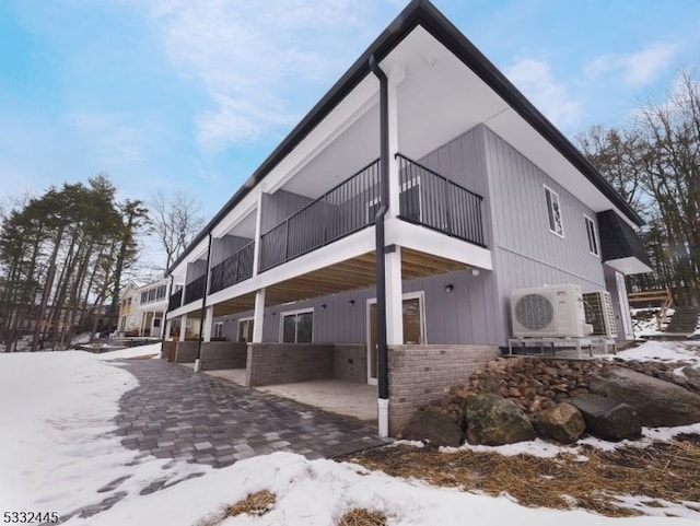 snow covered property with ac unit