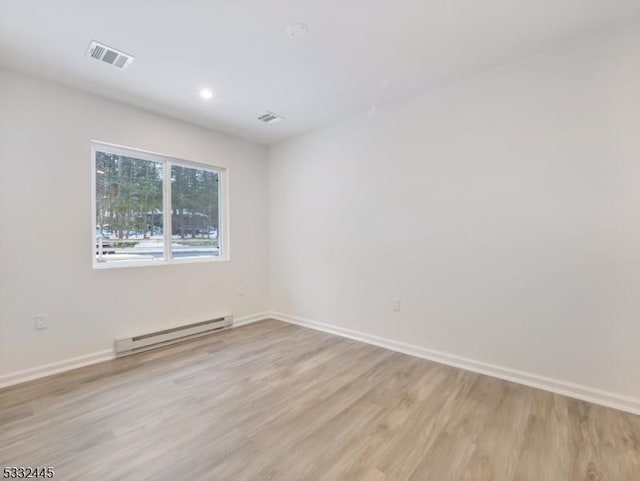 spare room featuring light hardwood / wood-style floors and a baseboard heating unit