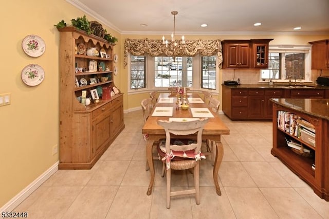 dining space featuring sink, an inviting chandelier, light tile patterned flooring, and ornamental molding