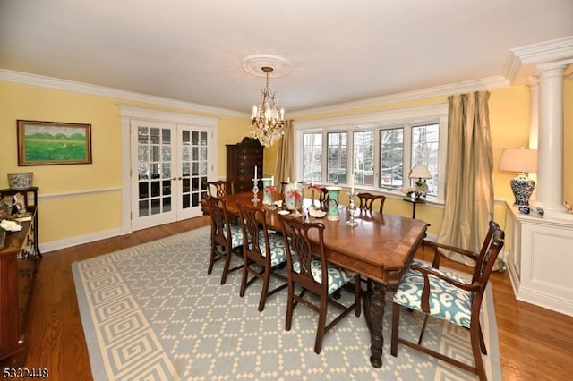 dining room with hardwood / wood-style floors, ornamental molding, and an inviting chandelier