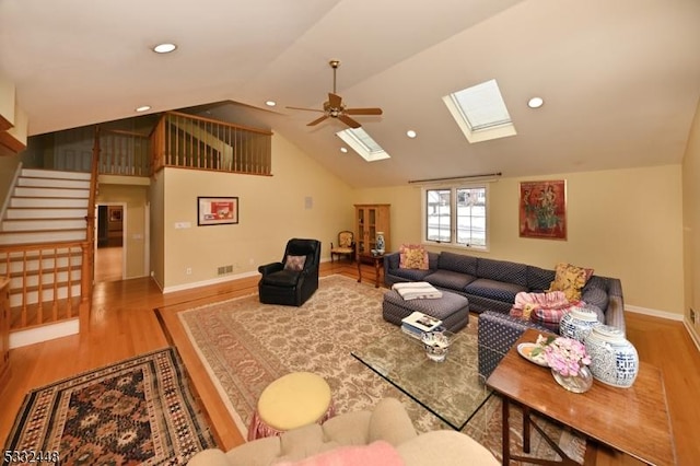 living room featuring vaulted ceiling, light hardwood / wood-style flooring, and ceiling fan