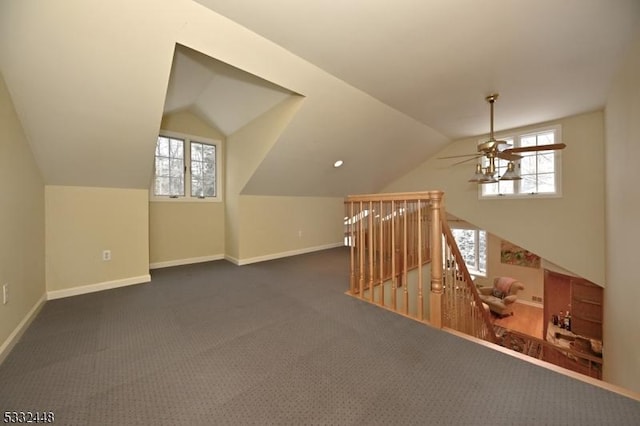 bonus room with dark colored carpet, ceiling fan, and vaulted ceiling