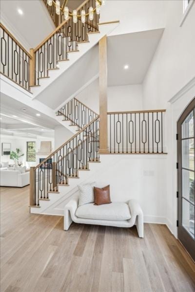 stairs with hardwood / wood-style floors and a towering ceiling