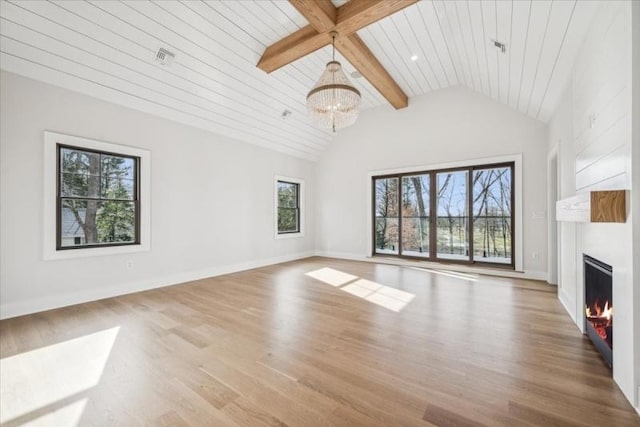 unfurnished living room with beam ceiling, a towering ceiling, an inviting chandelier, and wood-type flooring