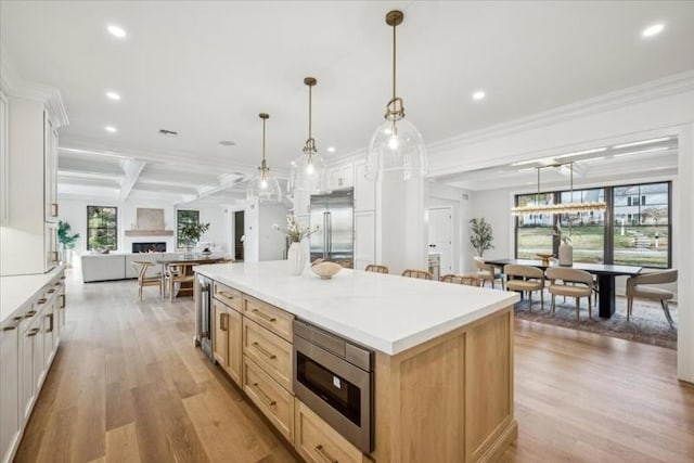 kitchen with white cabinets, built in appliances, and decorative light fixtures