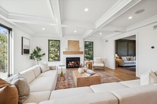 living room featuring beamed ceiling, a healthy amount of sunlight, light wood-type flooring, and coffered ceiling