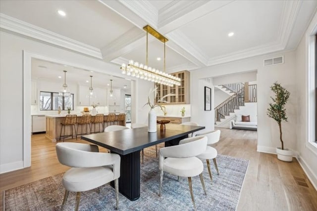 dining space with beamed ceiling, light hardwood / wood-style floors, and ornamental molding