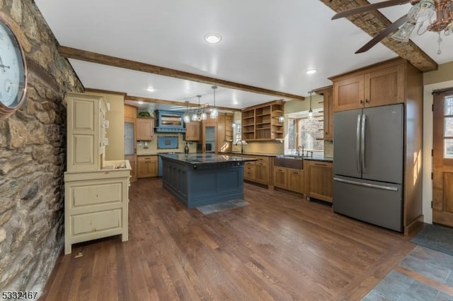 kitchen featuring a kitchen island, stainless steel refrigerator, hanging light fixtures, and beam ceiling