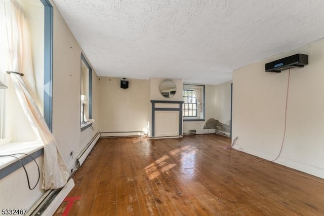 unfurnished living room featuring a textured ceiling, dark wood-type flooring, and a baseboard heating unit