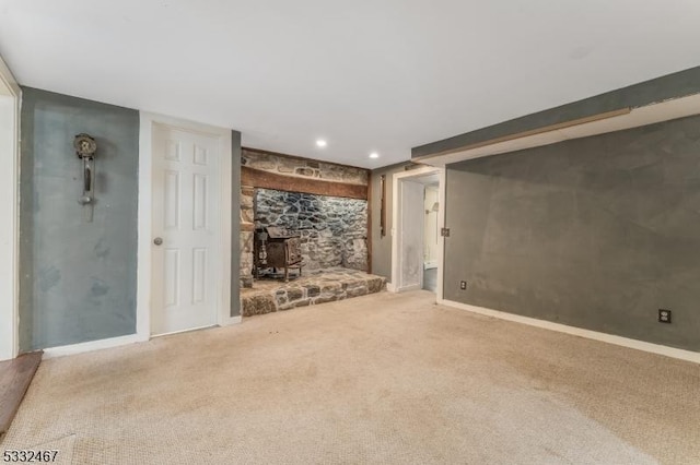 unfurnished living room featuring carpet floors and a wood stove