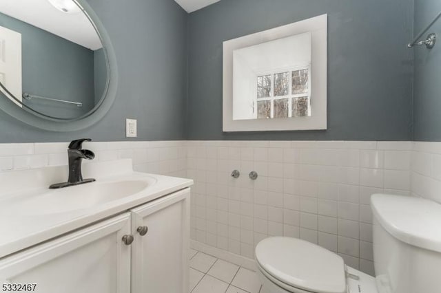 bathroom featuring tile walls, vanity, tile patterned floors, and toilet