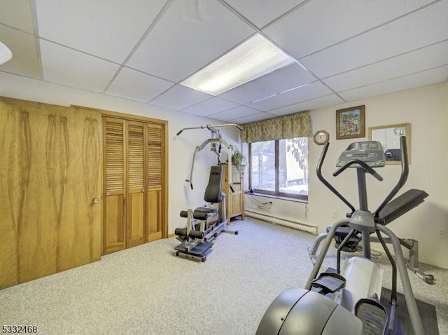 exercise area featuring a drop ceiling, carpet, and a baseboard radiator