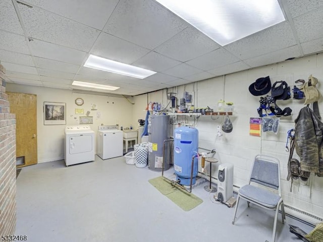 below grade area with a drop ceiling, independent washer and dryer, a sink, and electric water heater