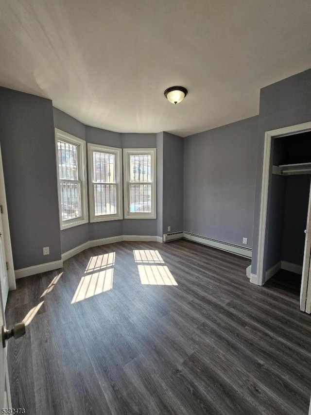 unfurnished bedroom featuring baseboard heating and a closet