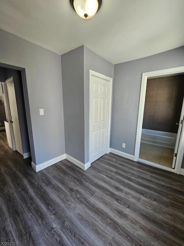 unfurnished bedroom with dark hardwood / wood-style floors and a closet