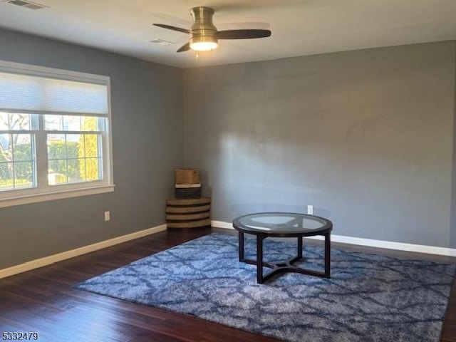 living area with ceiling fan and dark hardwood / wood-style flooring