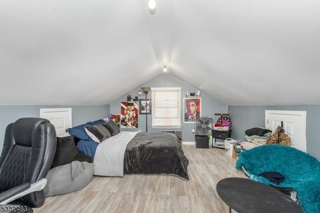 bedroom featuring light hardwood / wood-style floors and lofted ceiling