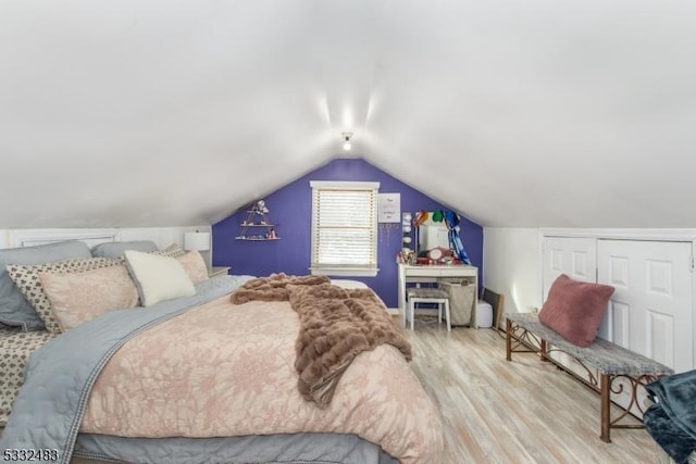 bedroom featuring a closet, vaulted ceiling, and light wood-type flooring