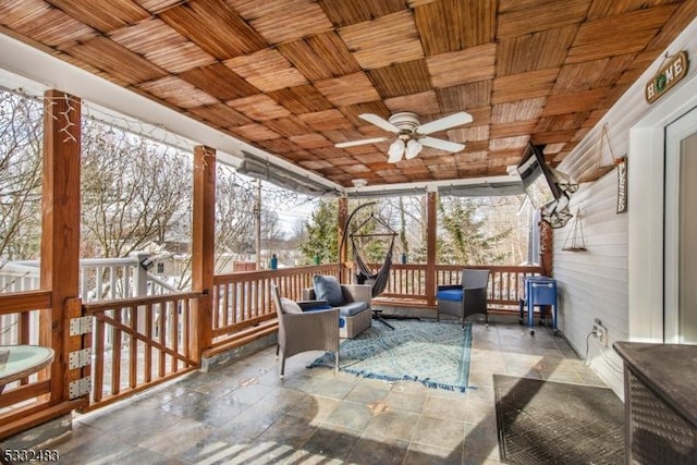 sunroom with ceiling fan, plenty of natural light, and wood ceiling