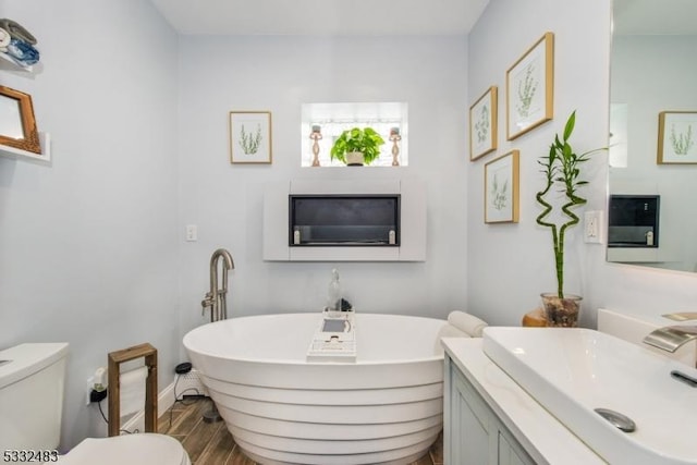 bathroom featuring a tub to relax in, sink, and toilet