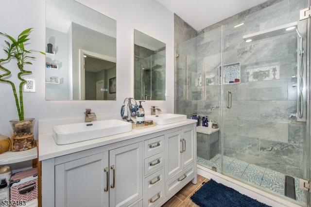 bathroom with wood-type flooring, vanity, and a shower with door