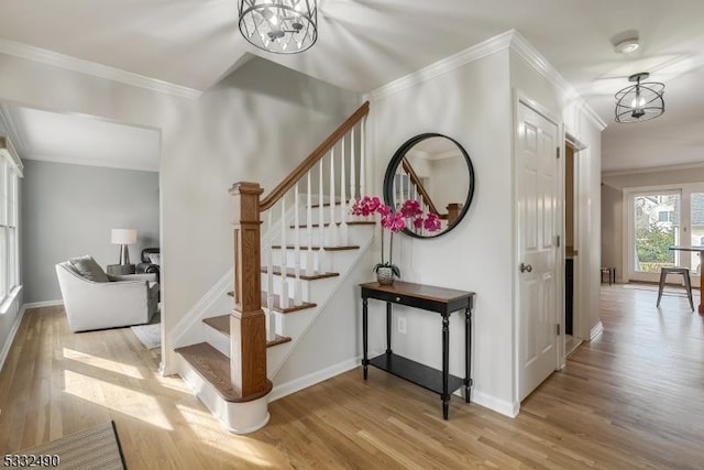 interior space featuring ornamental molding, light hardwood / wood-style floors, and a notable chandelier