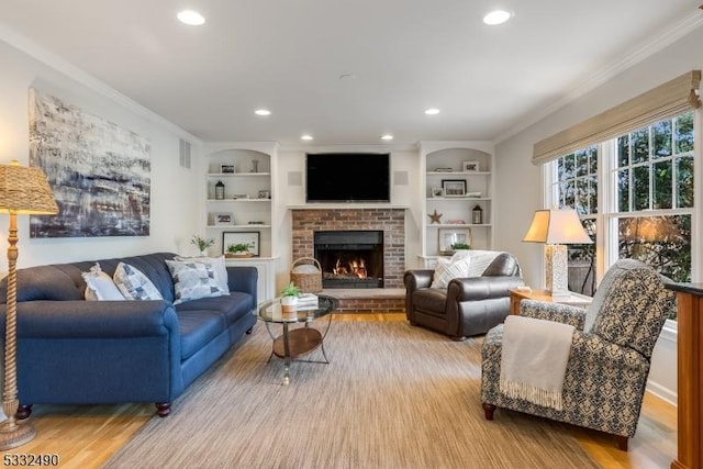 living room with built in features, ornamental molding, and a brick fireplace