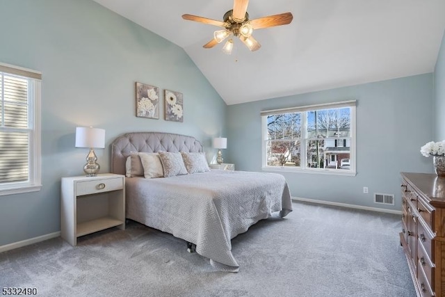 carpeted bedroom with ceiling fan, vaulted ceiling, and multiple windows