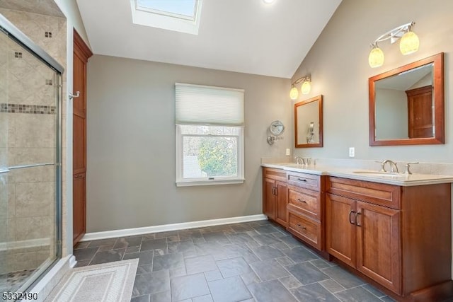 bathroom featuring lofted ceiling with skylight, vanity, and an enclosed shower