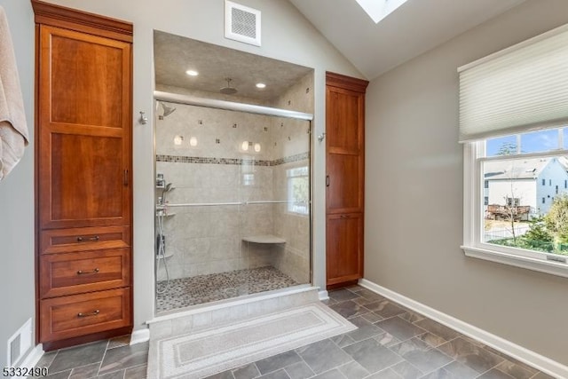 bathroom with lofted ceiling with skylight and walk in shower