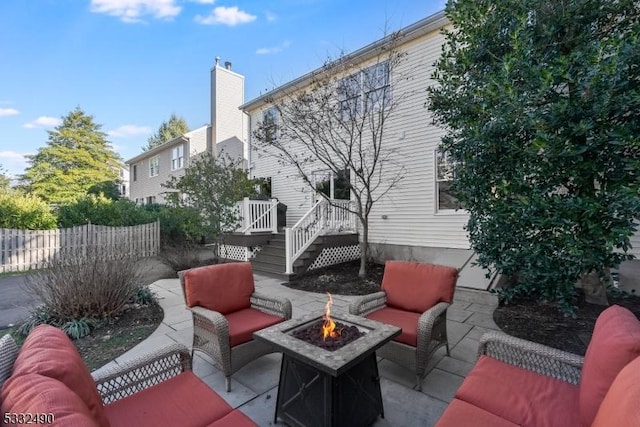 view of patio with an outdoor living space with a fire pit