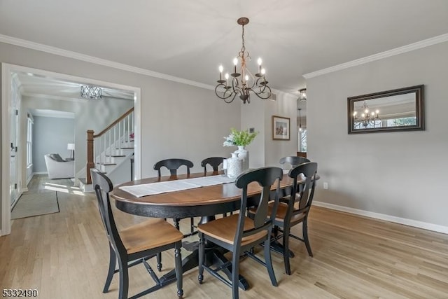 dining room featuring light hardwood / wood-style flooring, ornamental molding, and a chandelier