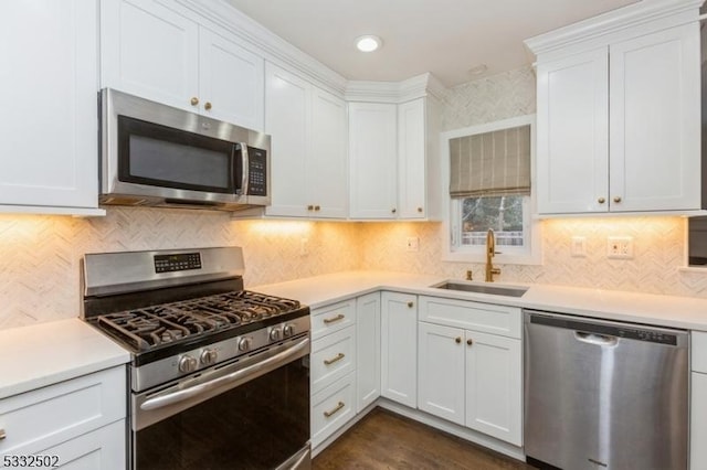 kitchen with stainless steel appliances, white cabinetry, and sink