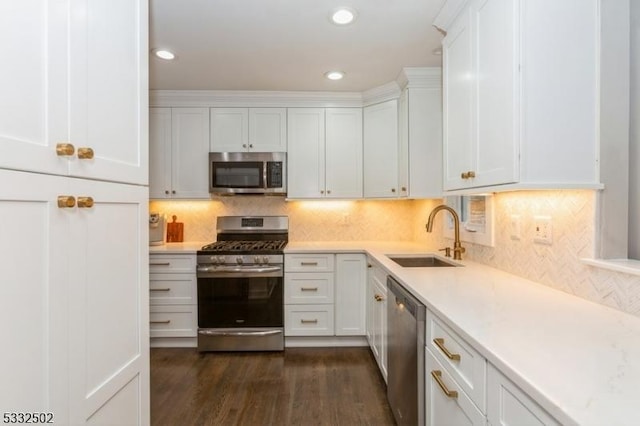 kitchen featuring stainless steel appliances, sink, white cabinets, decorative backsplash, and dark hardwood / wood-style floors