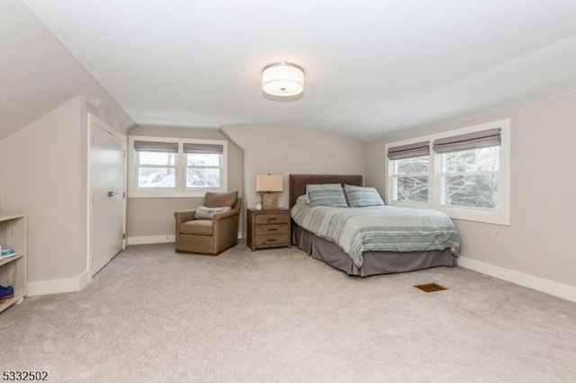 carpeted bedroom with vaulted ceiling and multiple windows