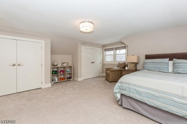 bedroom featuring light colored carpet, a closet, and vaulted ceiling