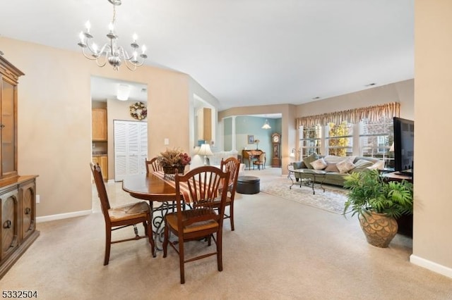 dining space featuring light colored carpet and a chandelier