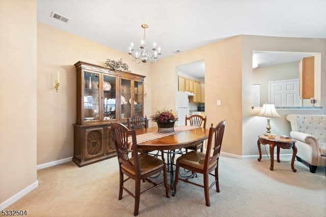 carpeted dining area with a notable chandelier