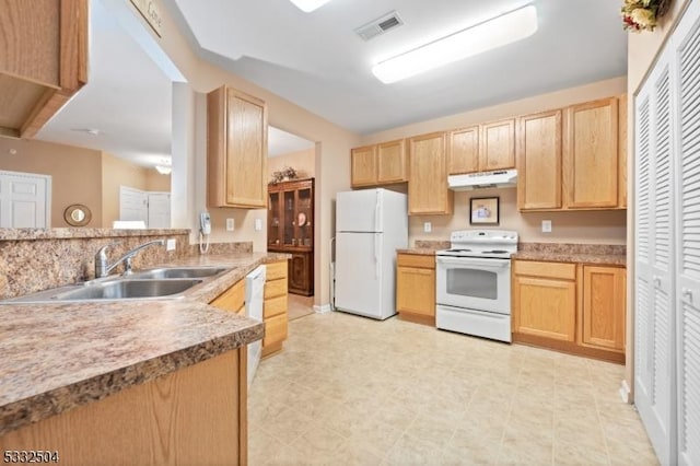 kitchen featuring white appliances, light brown cabinetry, and sink