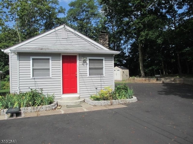 bungalow-style home featuring a shed