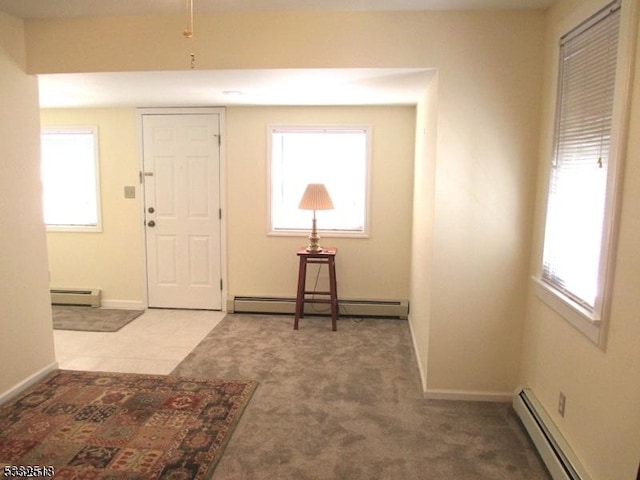 foyer entrance with carpet and a baseboard heating unit