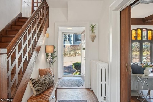 entryway with parquet flooring and radiator heating unit